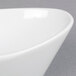 A CAC Super White Porcelain Oval Fruit Dish with a curved edge.