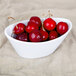 A white CAC porcelain oval fruit bowl filled with red fruit.
