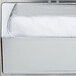 A Vollrath stainless steel napkin dispenser with a chrome faceplate holding white napkins.
