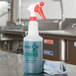 A 32 oz. Noble Chemical All Purpose Cleaner and Degreaser spray bottle with a red and white sprayer and a rag on a counter.