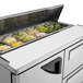 A Turbo Air refrigerated sandwich prep table with food trays in a container.