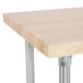 An Advance Tabco wood top work table with stainless steel legs and base.