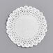 A 5" white Normandy lace doily on a gray surface.