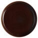 A brown Tuxton pizza serving plate with a black rim and circular pattern.