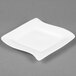 A CAC Miami bone white square porcelain plate with a curved edge.