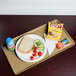 A Cambro Bayleaf Brown dietary tray on a table with a sandwich, chips, and a blue drink.