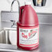 A red and white bottle of Noble Chemical Clog B-Gone liquid on a sink counter.