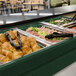 A green Cambro table top buffet with trays of food.