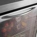 A Turbo Air undercounter refrigerator with a glass door filled with fruit including apples, pineapples, and grapes.