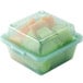 A jade green plastic GET reusable container filled with sliced fruit.