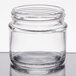 A Tablecraft clear glass tasting jar with a lid on a table.