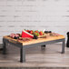 A Tablecraft butcher block riser with food on it.