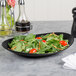 A Libbey Driftstone Onyx satin matte porcelain coupe plate with a salad on it.