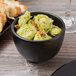 A Libbey Driftstone onyx porcelain bouillon filled with pasta and bread on a table.