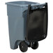 A grey plastic Rubbermaid trash can with a black lid and black wheels.