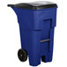 A blue Rubbermaid commercial trash can with black wheels and a black lid.
