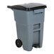 A grey Rubbermaid commercial trash can with a black lid.