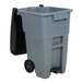 A Rubbermaid grey rectangular trash can with wheels and a black lid.