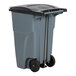 A grey Rubbermaid commercial trash can with black wheels.