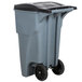 A grey Rubbermaid commercial trash can with wheels and a black lid.