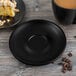 A Libbey Onyx satin matte porcelain saucer with a slice of cake and a mug of coffee on it.