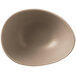 A close up of a Libbey Driftstone Sand Satin Matte organic porcelain bowl on a white surface.