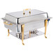 A Vollrath stainless steel chafing dish with brass trim on a table outdoors.
