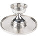 A silver tray with a Cal-Mil stainless steel cake stand on it.