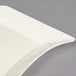 A white plastic Fineline dessert plate with a curved corner.