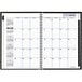 A spiral bound black DayMinder monthly planner for December 2023 - January 2025 with white pages.