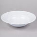 A white bowl with ripples on a white surface.