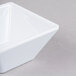 A close up of a white Elite Global Solutions squared melamine bowl.