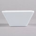 A white square Elite Global Solutions melamine bowl on a gray surface.