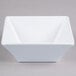A white square Elite Global Solutions melamine bowl with a square base.