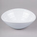A white Elite Global Solutions swirl melamine bowl on a gray surface.