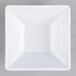 A white square bowl with black edges on a gray surface.
