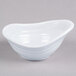 A white oblong melamine sauce dish on a gray surface.