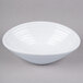 A white oblong melamine bowl with a circular design on a gray surface.