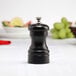 A black Chef Specialties Capstan Ebony pepper mill on a table.