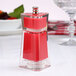 A red Chef Specialties Kate salt / pepper mill on a table.