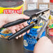 A person using a Garde handheld crank can opener to open a can.