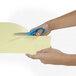 A person's hand holding Westcott Ergo Jr. Kids Scissors with a bent handle cutting yellow paper.
