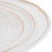 An off white Elite Global Solutions irregular oval serving dish with a brown rim.