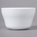 A white Elite Global Solutions Merced melamine bowl on a gray surface.