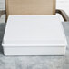 A white rectangular melamine box with a white edge on a table.