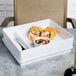A white Elite Global Solutions melamine tray with food in 2 compartments.