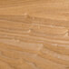 A close-up of a BFM Seating natural veneer wood table top with wood grain and some scratches.