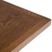 A close up of a BFM Seating 36" Square Autumn Ash Veneer table top.