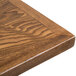 A BFM Seating Autumn Ash veneer wood table top on a table.