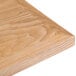 A close up of a BFM Seating natural veneer wood table top.